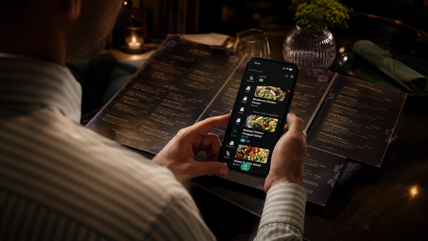A diner reading a menu by phone light in a dimly lit restaurant